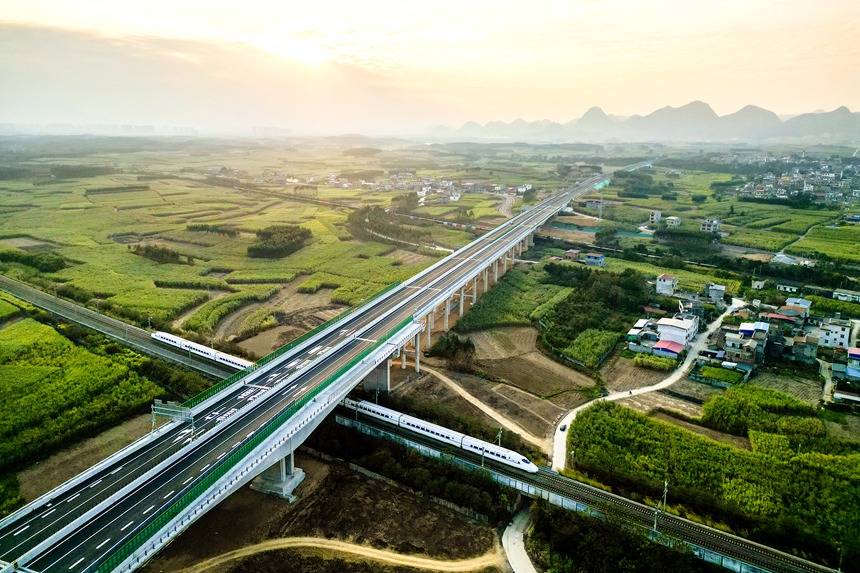 列車從廣西單體噸位最大轉體橋——武忻高速維都上跨鐵路分離式立交特大橋飛馳而過。贠文豪攝