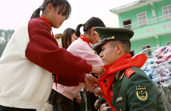 学生为武警官兵佩戴红领巾。