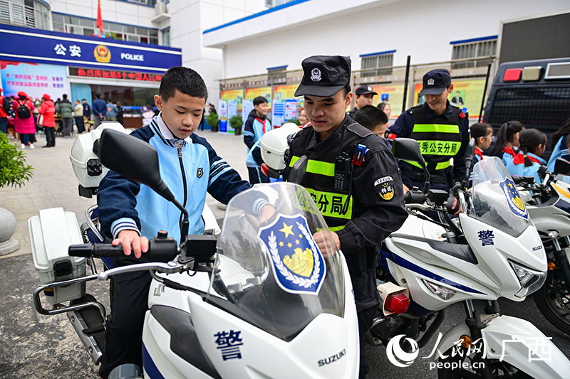 警务人员在给小朋友介绍警用摩托车。人民网 雷琦竣摄