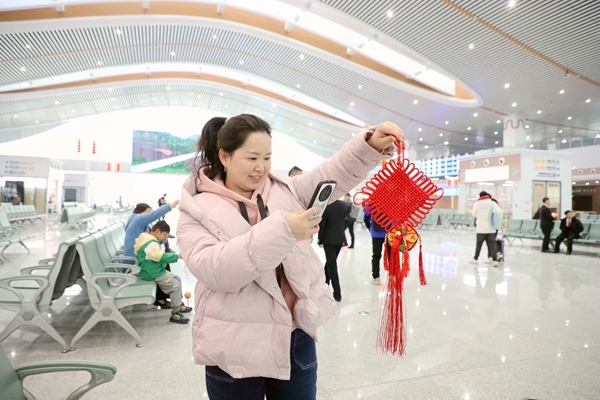 春运首日，玉林北站工作人员为旅客送上中国结、绣球，将“鬰林祝福”送给广大旅客。陈海婵摄