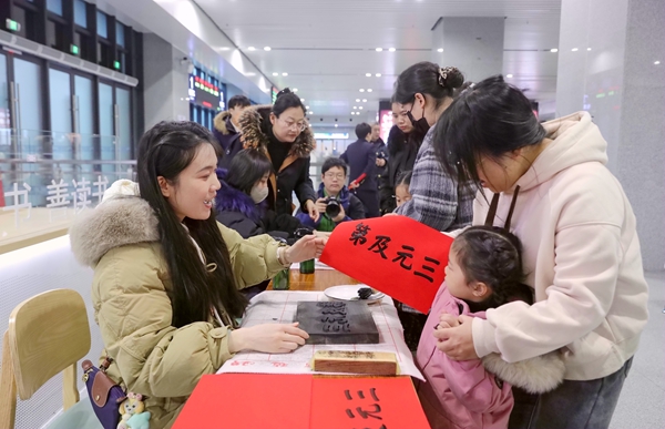 旅客在桂林站候车室体验非物质文化遗产“雕版印刷”活动 。郑长贤摄