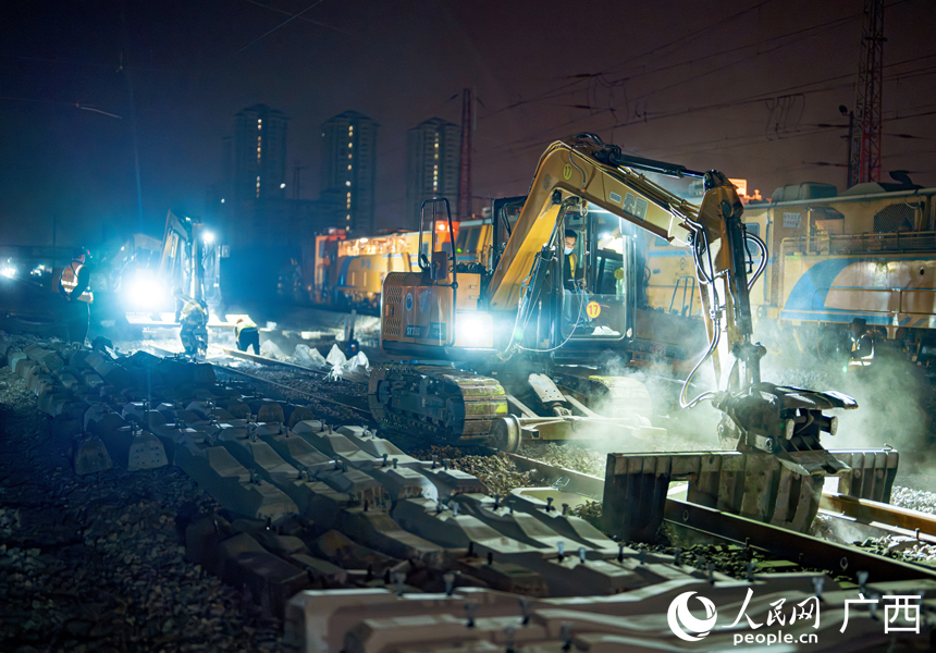 换枕钩机在铁路线上清理石砟。人民网记者 王勇摄