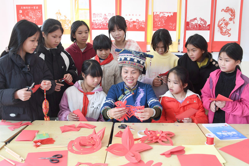 罗华清在教授孩子们剪新春剪纸饰品。