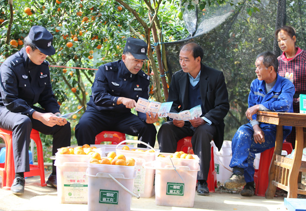 民警向果园游客宣传反诈知识。