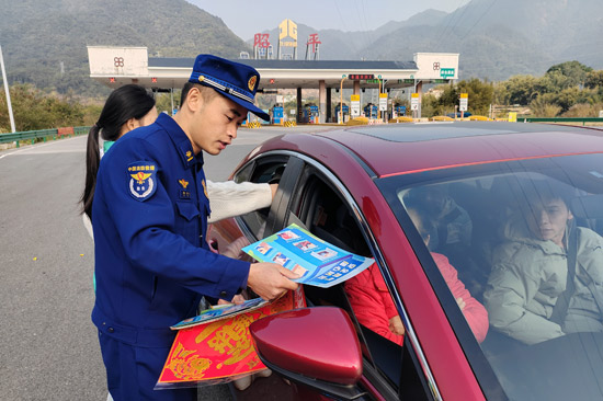 消防宣傳員在向過往駕駛員科普消防知識，並贈送新年小禮品。馮韻詩攝