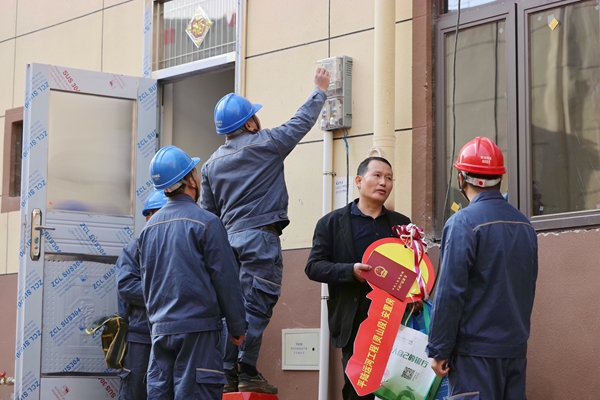 南方电网广西钦州灵山供电局陆屋供电所党员服务队到平陆运河沙坪集镇安置区进行走访，向搬迁户黄周雪了解用电需求和讲解安全用电注意事项。（陈心诚）.jpg