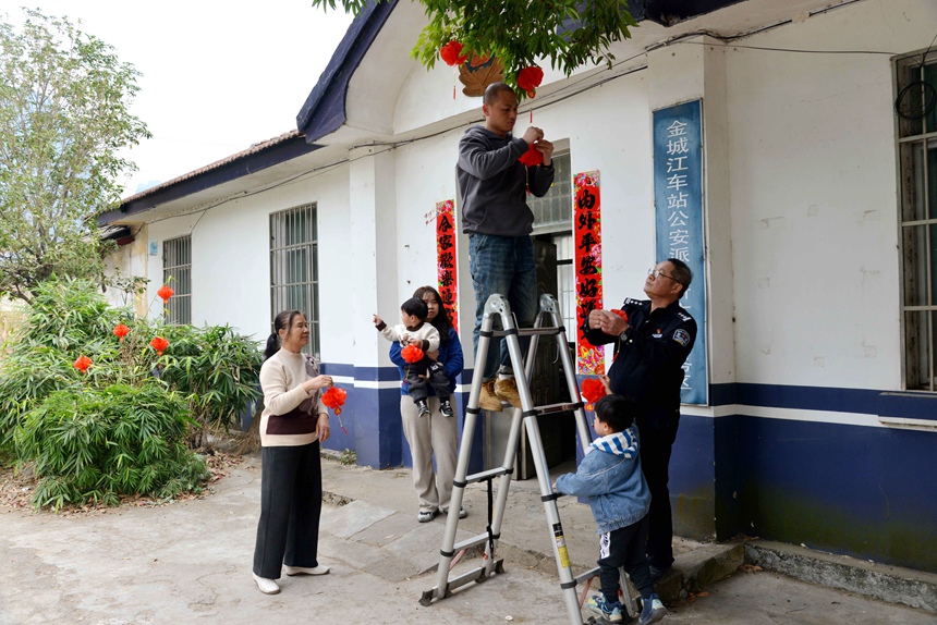 覃柳宜及家人在警务区门口树上挂灯笼。孙赟飞摄