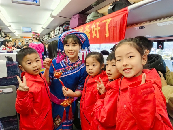 圖為列車長陳微（左二）身穿民族服裝在列車上開展活動 劉媛 攝