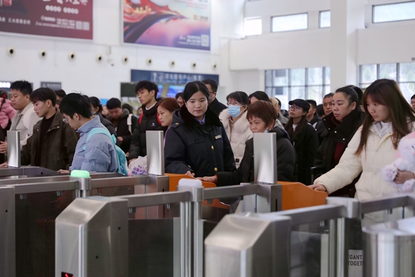 韋艷花引導老年旅客刷証檢票乘車。李洪銳攝