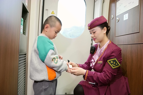 圖為列車長楊亞楠為乘車的孩子發小獎狀。曹爍攝