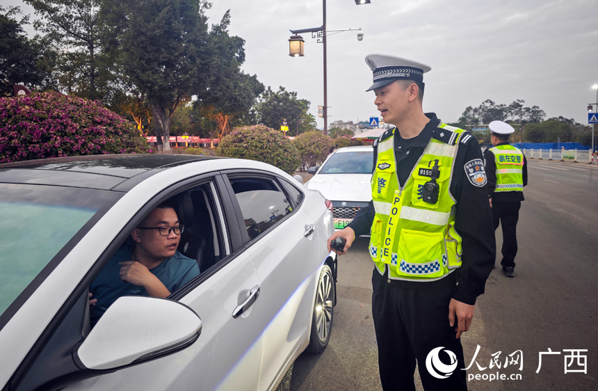 崇左市公安局交警支队民警杨龙章提醒车主注意安全。人民网记者 张芳摄