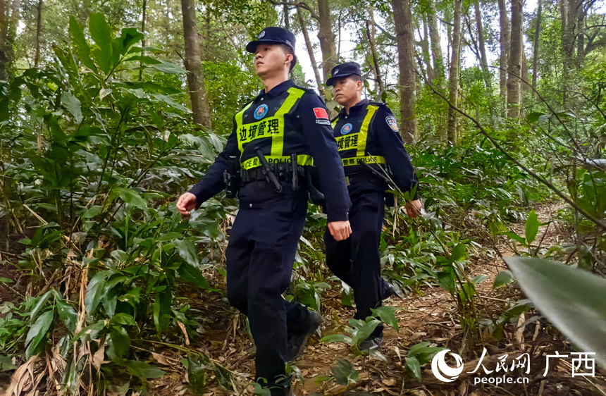 崇左边境管理支队彬桥边境派出所民警傅彬（左一）在山林里巡逻。人民网记者 张芳摄