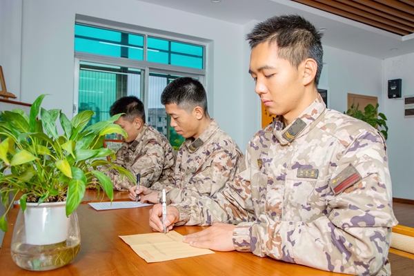 武警官兵们正在写家书。