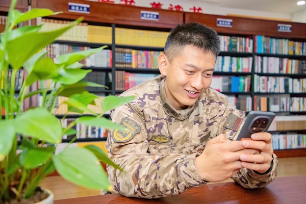 一名武警官兵正在与家人通视频。