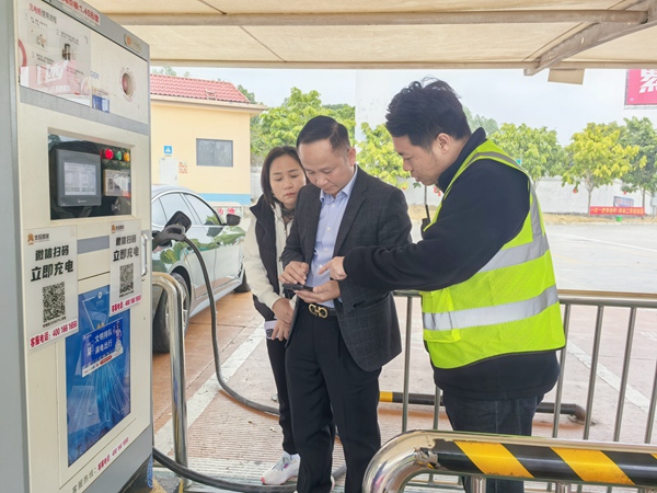 協助旅客進行新能源車輛充電。黃敏攝