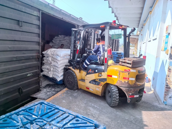 叉车、人力协同卸化肥作业现场。陈鑫摄