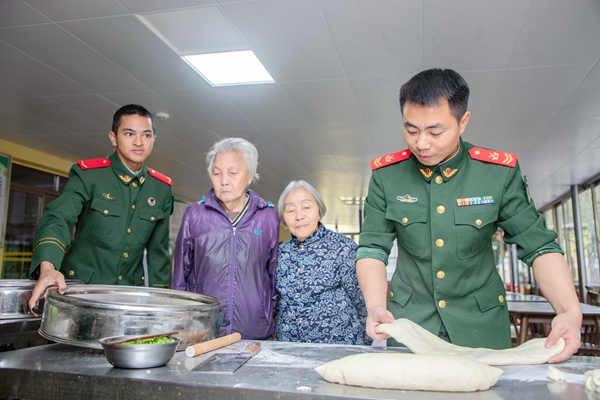 武警官兵与老人们一同制作面食。