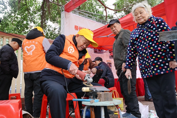 雷锋街市志愿者在帮市民磨刀。戴佩芸摄