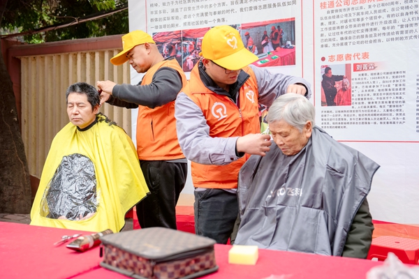 雷锋街市志愿者在为市民理发。蒋少阗摄