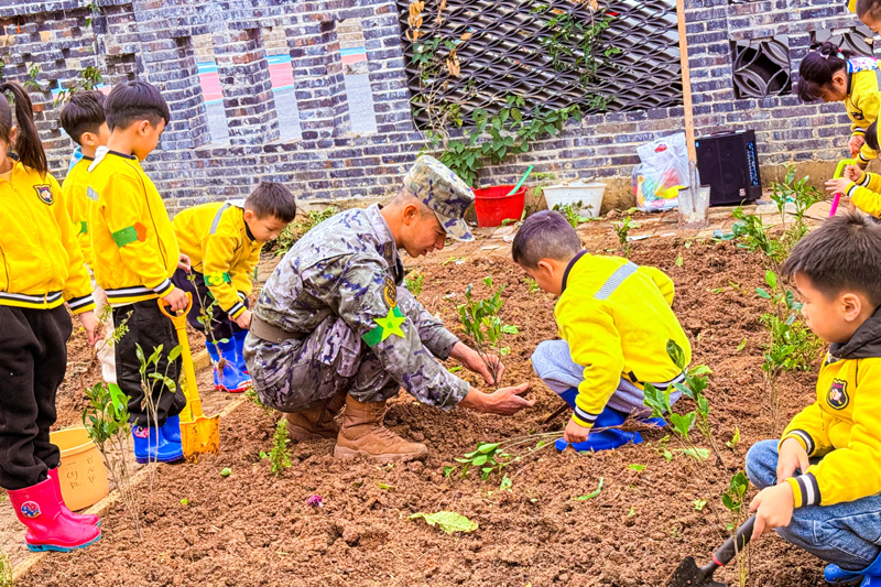 武警官兵手把手教小朋友植樹。廖濤攝