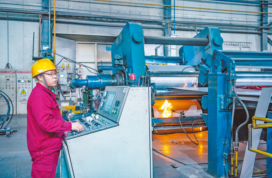工人专注地操作机器设备,稳定生产出高质量合格产品。任小婴摄