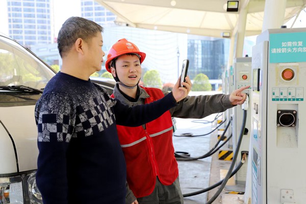电力员工指导市民充电。