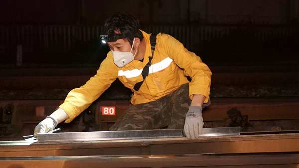 该段职工正在使用钢尺对钢轨廓形进行检查。陈健摄
