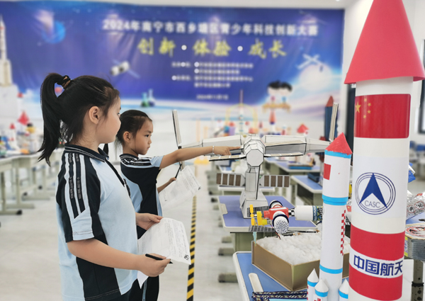 4月24日，南寧市北湖路小學“探索星空奧秘，鑄造航天能手”創意航天模型展驚艷亮相。學生認真觀摩學習其他同學制作的航天模型作品。學校供圖