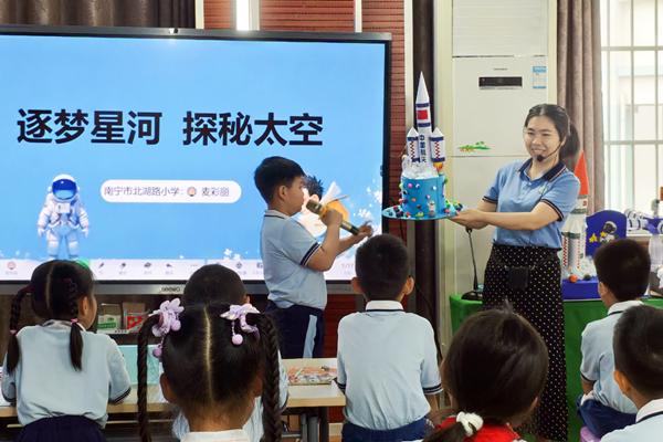 4月24日，南寧市北湖路小學舉辦“海上生明月，九天攬想和”中國航天日主題教研活動，科學學科麥彩麗老師課上協助學生介紹制作的航天模型。學校供圖
