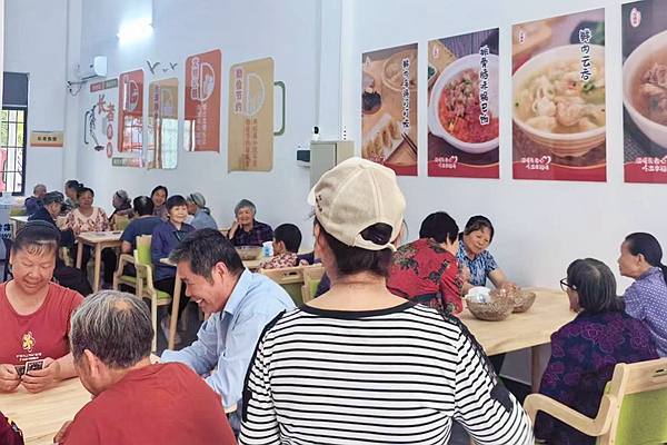 老人在社区爱心食堂体验餐食。覃友丽摄