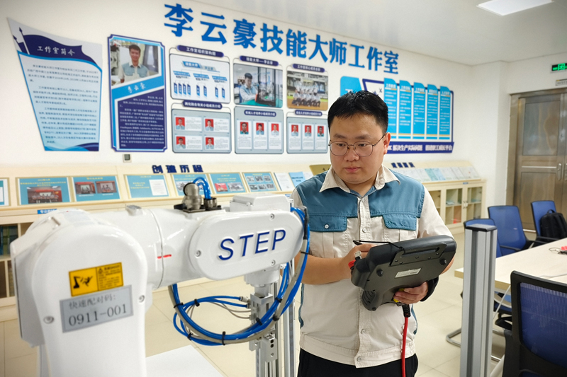 唐俊在工作室训练埃夫特机器人。广西中烟供图