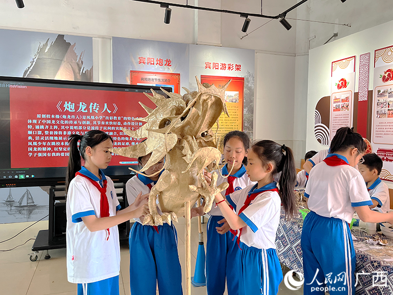 学生们在学习制作炮龙。人民网 韦欢摄