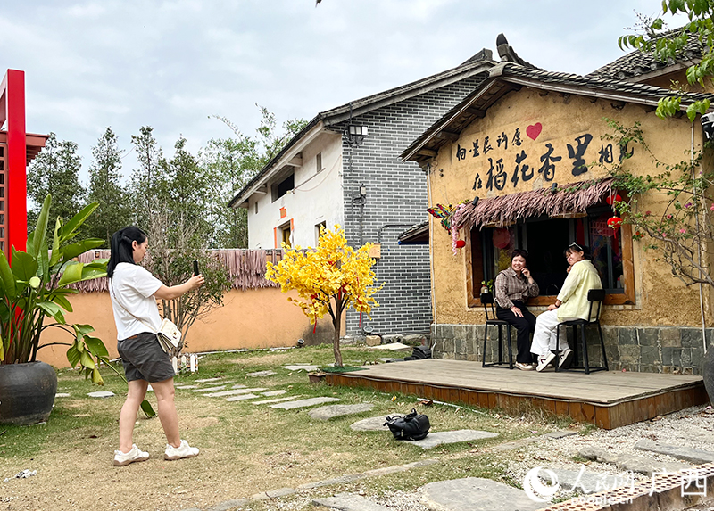 游客在古辣镇稻花香里旅游景区内拍照打卡。人民网 韦欢摄