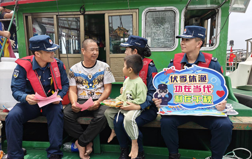 执法员向渔民宣传《中华人民共和国海警法》。广西海警局供图