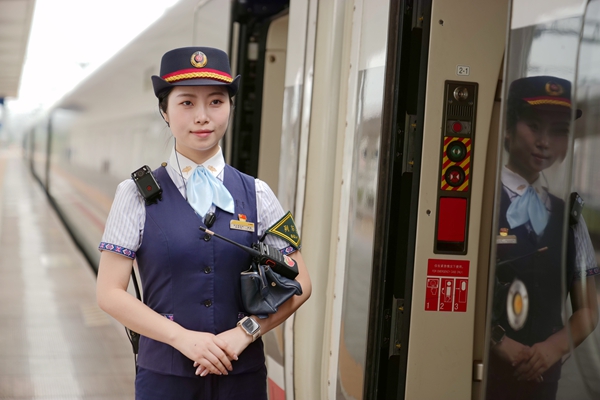 列车长梁祺立岗迎接旅客上车。曾雨琦摄