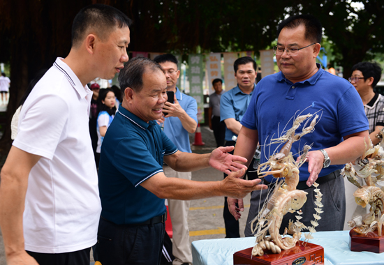 国家级非遗代表性传承人白耀华现场介绍角雕作品。李海华摄