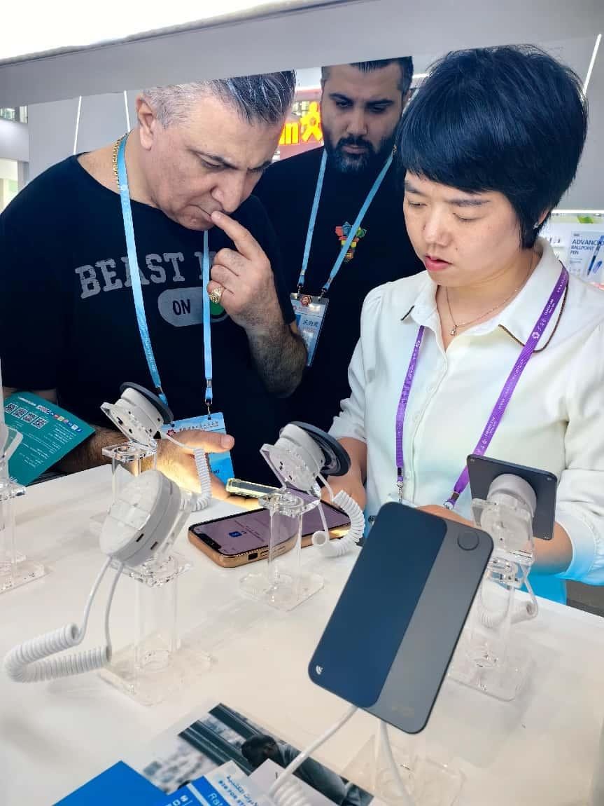 展台工作人员向外国客商展示“AI TOP翻译终端”。图片由相关方提供