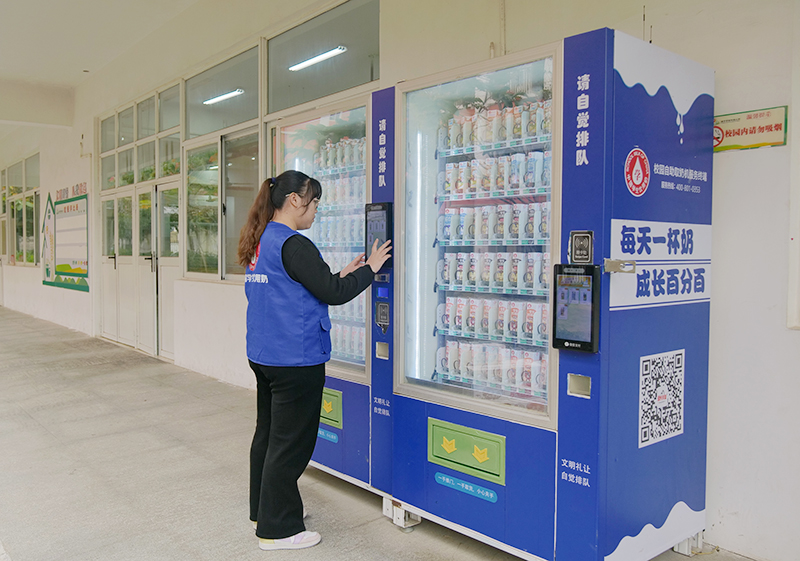 学生奶运营专员在检查校园自助取奶机。何善权摄
