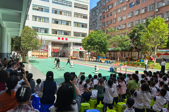 师生观看机器人和机器狗表演。