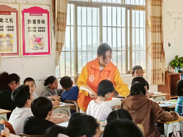 图为青年职工在为小学生发放铁路安全宣传物品。杜宇摄