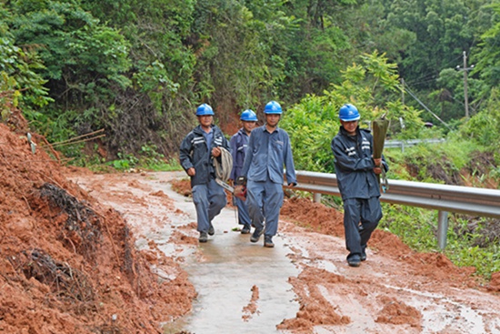 5月18日，因道路受阻，南方电网广西玉林北流供电局工作人员沿着受灾线路进行勘查。邓有雄摄