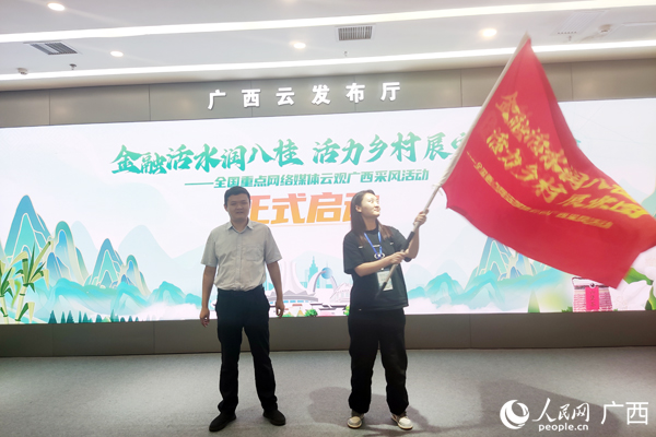 自治区党委金融办（农办）农村工作处相关负责人向采风团授旗。人民网记者 王勇摄