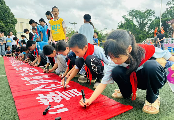 孩子们在“警企护苗 安全‘童’行”主题横幅上郑重签名.jpg