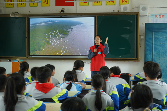 在巫头小学,南方电网红树林白鹭保护队队员在向小学生们宣传护林护鹭小知识。熊秋月摄