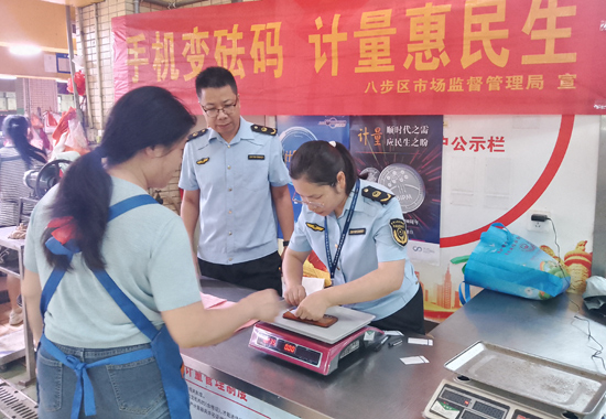 工作人员在八步中心市场为群众提供手机变砝码服务