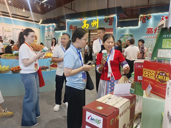 图为供应商在荔枝博览会上推荐忻城农特产品