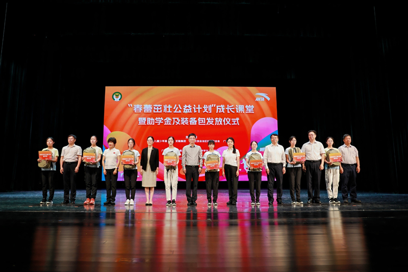 与会嘉宾共同为受助学生代表发放助学金及装备包。李京朗摄