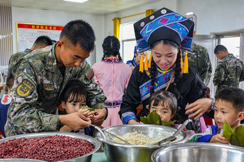 官兵与幼儿园师生共同包粽子。王超智摄