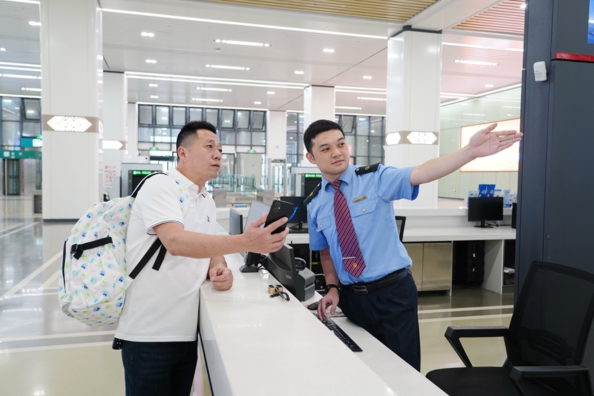 吴圩机场站客运员解答旅客问讯。梁竞辉摄