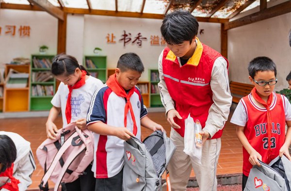 志愿者为定点帮扶的困难学生带去学习用品